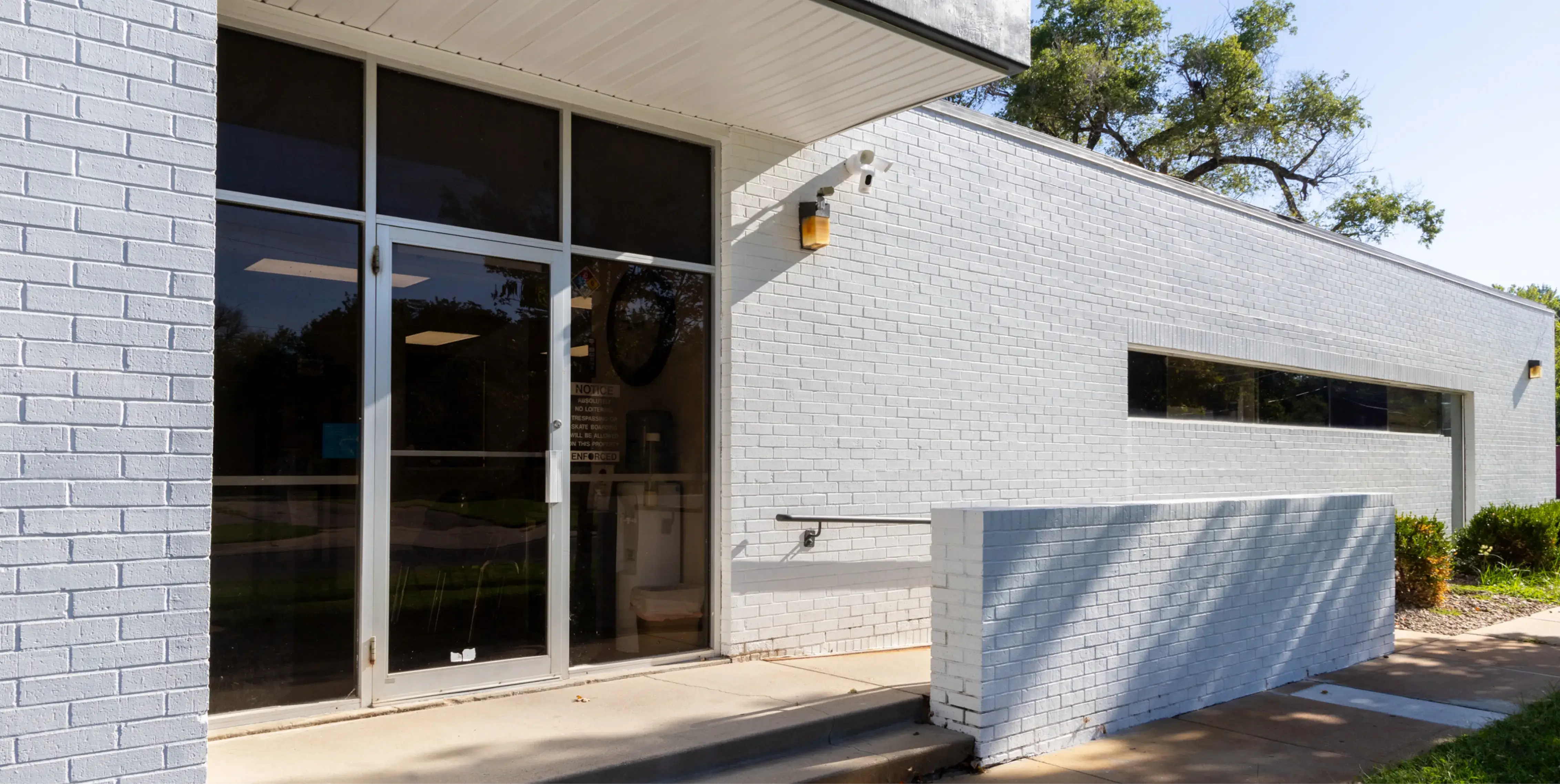 a white brick building with glass doors and windows