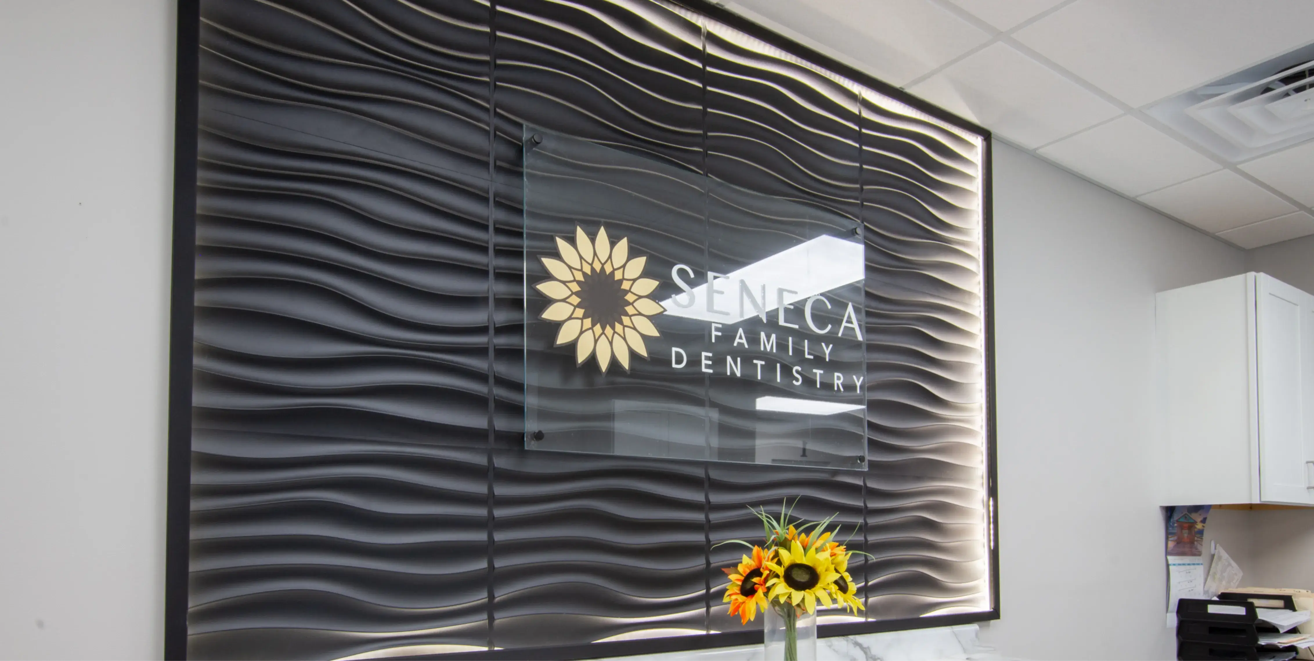 a glass window with a sunflower in a vase